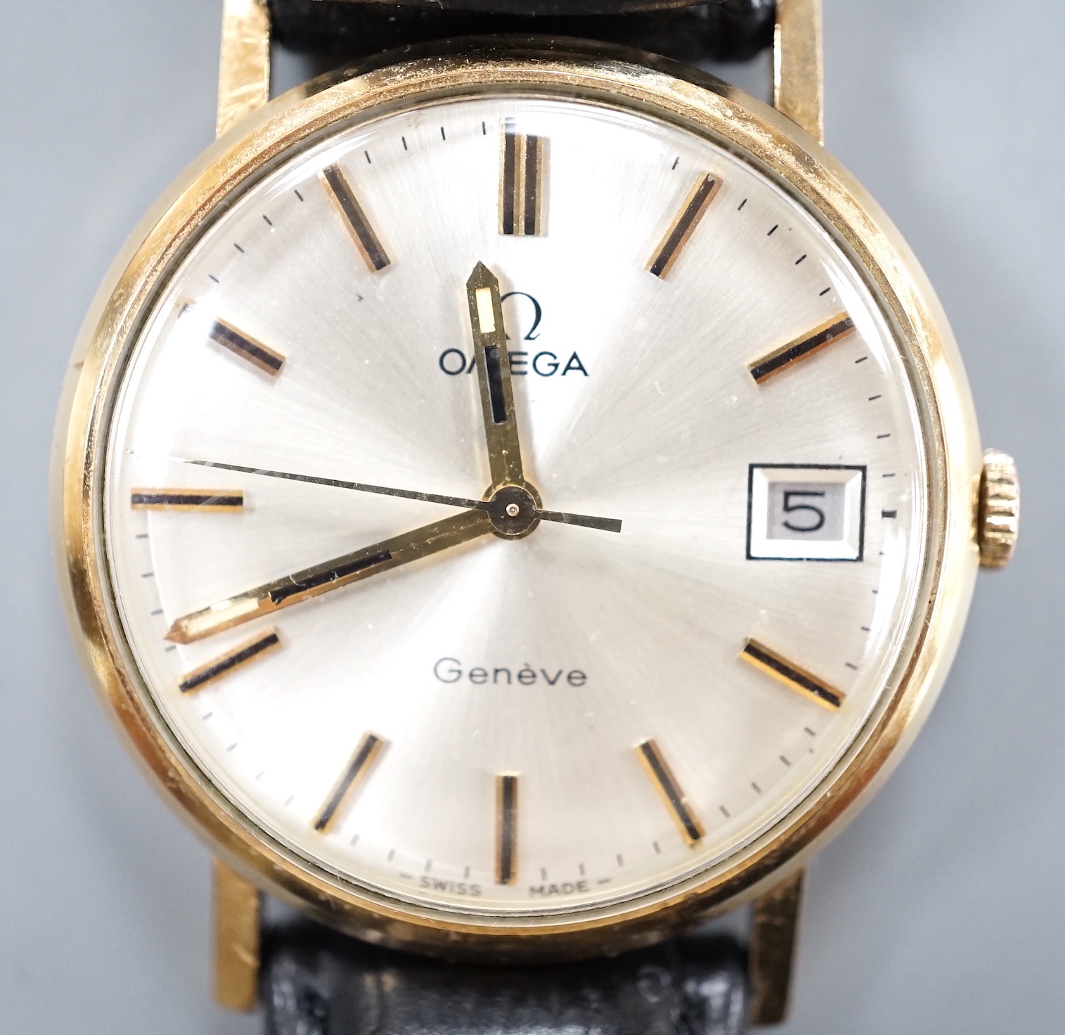 A gentleman's 9ct gold Omega manual wind wrist watch, with date aperture, on a black leather Omega strap with Omega buckle, cased diameter 33mm